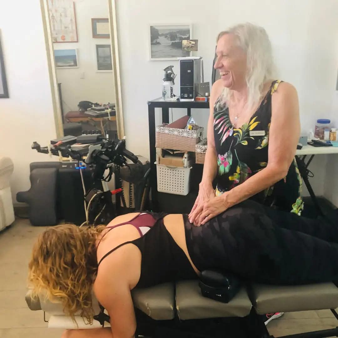 Dr. Colby smiling while treating a patient on the adjustment table