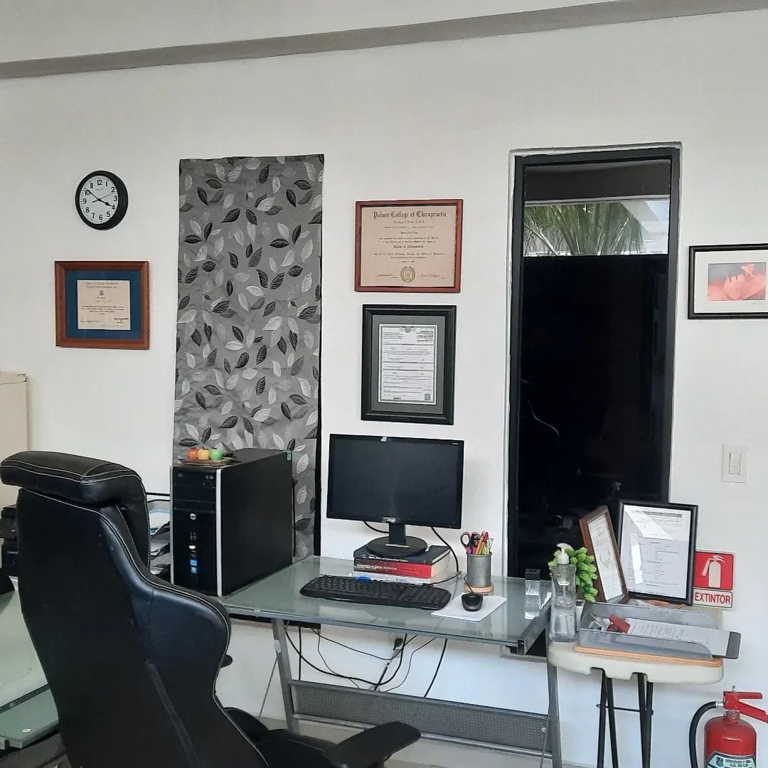 Dr. Colby's office wall with her Palmer College diploma and credentials